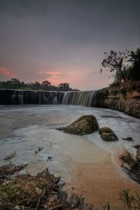 Scenic view of river against sky at sunset