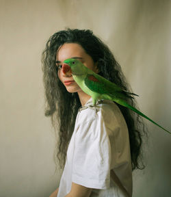 Portrait of man wearing sunglasses standing against wall