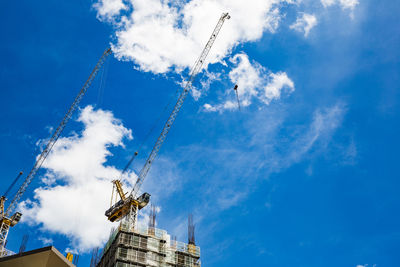 Low angle view of crane against blue sky