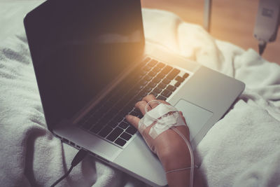 High angle view of patient using laptop on bed