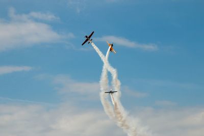 Low angle view of airplane flying against sky