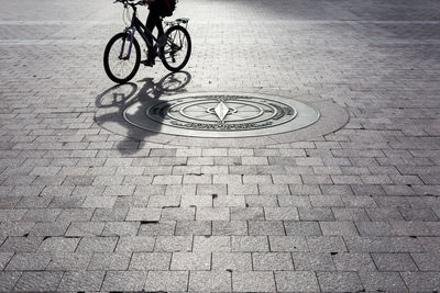 Low section of person riding bicycle on footpath