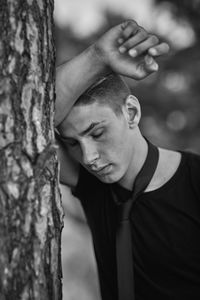 Portrait of man against tree trunk