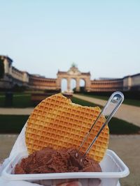 Close-up of fresh dessert at historic building against clear sky