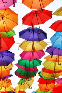 Low angle view of umbrellas hanging against sky