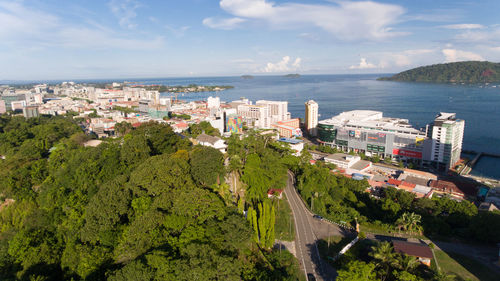 High angle view of buildings by sea against sky