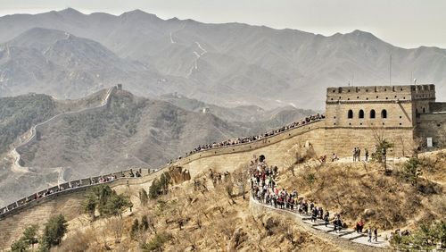 Group of people on the great wall of chins against mountain range