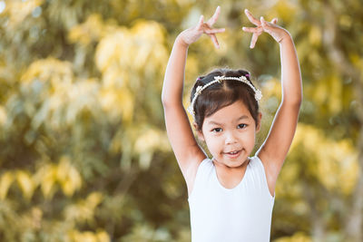 Portrait of girl dancing against plants