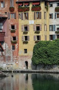 Canal by buildings in city