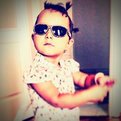 Portrait of boy wearing sunglasses at home