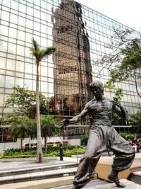 Low angle view of statue against trees in city