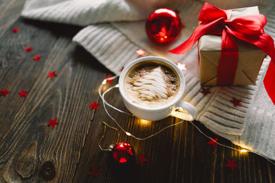 Christmas cup of coffee with sweater and christmas decorations.