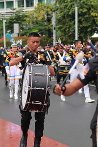 Other men play the drums in a marching band