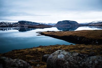 Scenic view of lake by mountain against sky