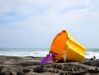 Close-up of yellow umbrella on beach