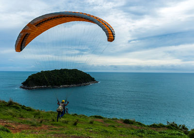 Rear view of person paragliding against sea