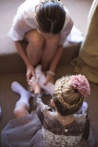 Mother wearing shoes to daughter at home