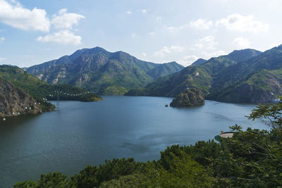 Scenic view of sea and mountains against sky