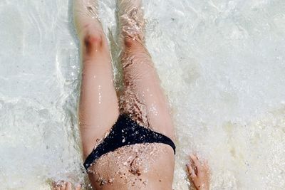 Low section of woman standing on beach