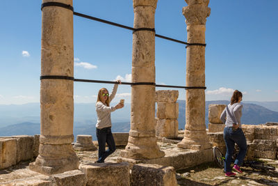 Friends by old ruins against mountain