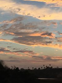 Scenic view of silhouette field against sky at sunset