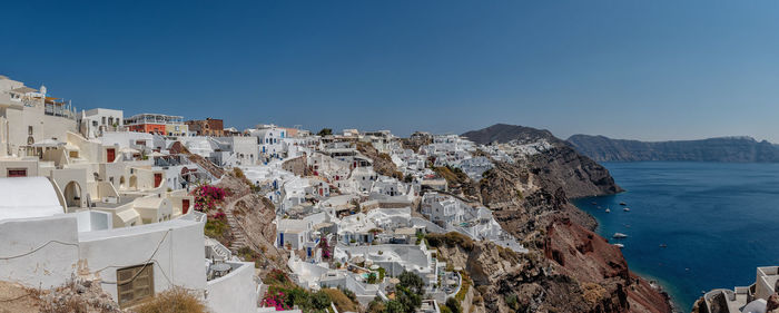 High angle view of townscape by sea against clear sky