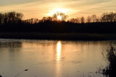 Scenic view of lake against sky during sunset