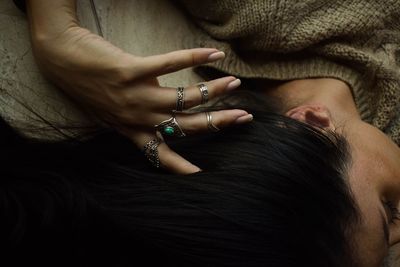 High angle of woman passing ringed fingers through her hair