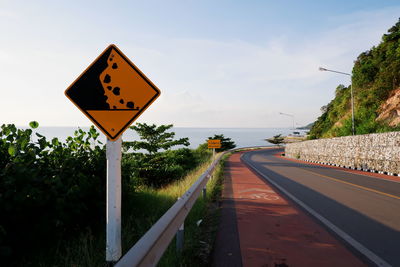 Road sign against sky