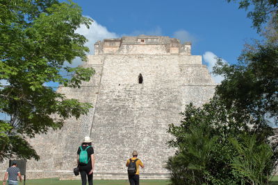 People at historical building against sky