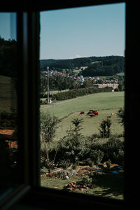 Scenic view of field against clear sky seen through window