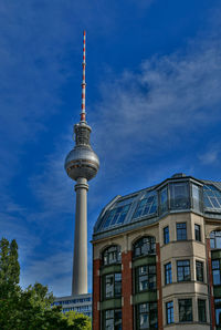 Low angle view of tv tower against cloudy sky in berlin