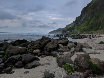 Rocks on beach against sky