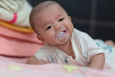 Portrait of cute baby lying on bed