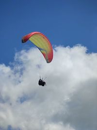 Low angle view of person paragliding against sky