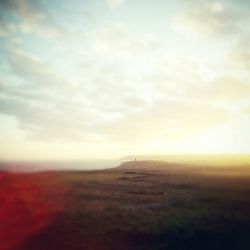 Scenic view of field against cloudy sky