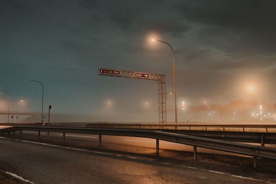 Street lights on road against sky at night