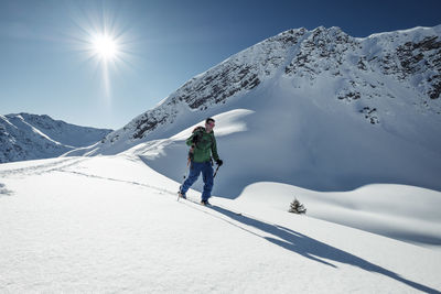 Man ski touring on snowcapped steinkarspitze, lechtal alps, tyrol, austria