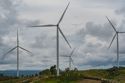 Windmills on field against sky