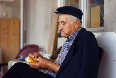 Side view of man looking at camera at home