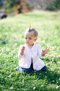 Cute girl sitting on grass outdoors