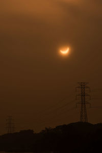 Silhouette electricity pylon against sky at night