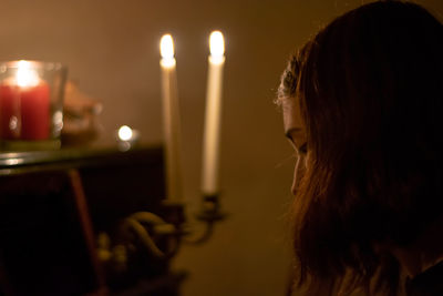 Midsection of woman with illuminated candles