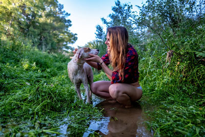 Woman with dog sitting on plants