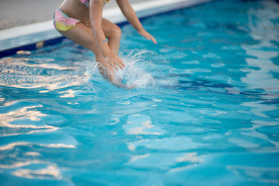 Low section of woman swimming in pool