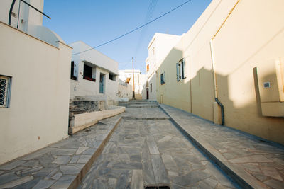 Footpath amidst buildings against sky