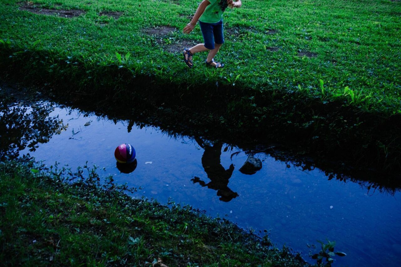 REFLECTION OF MAN IN PUDDLE