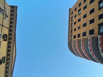 Low angle view of buildings against clear blue sky