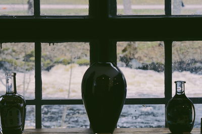 Close-up of beer bottle on glass window