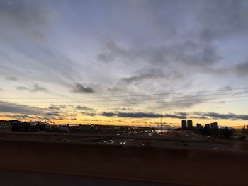 City street against sky at sunset